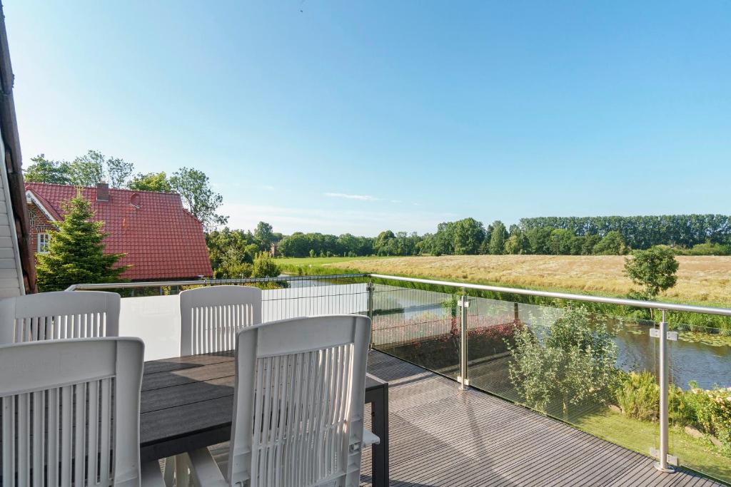 a balcony with chairs and a view of a river at Fewo Tief Blick in Dornum