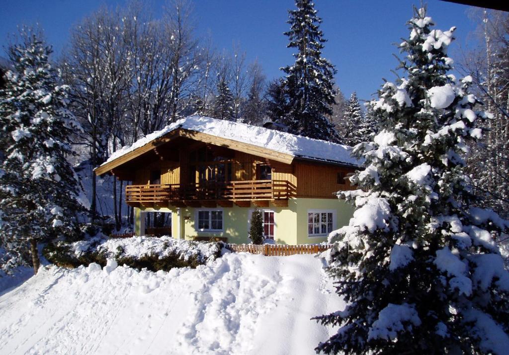 uma cabana de madeira na neve com árvores cobertas de neve em Appartement Pichler em Altenmarkt im Pongau