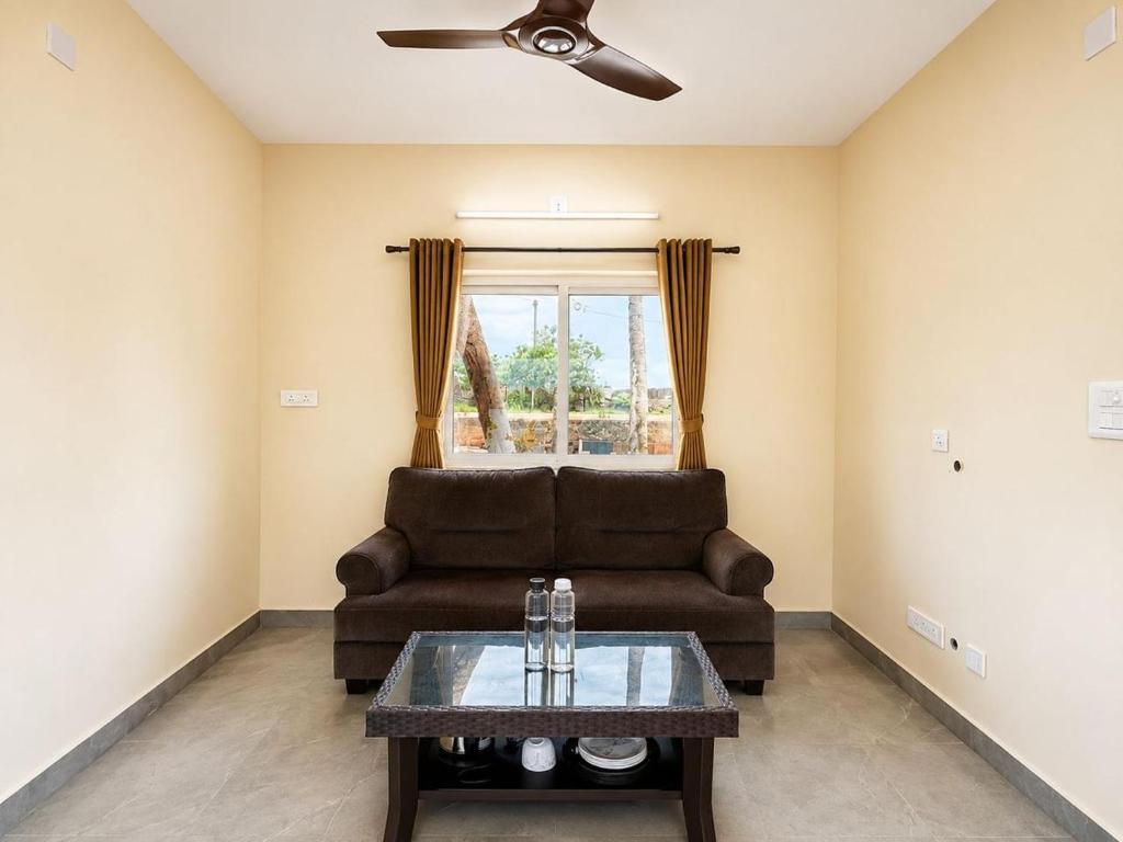 a living room with a couch and a table at Kadapu stay in Udiyāvara