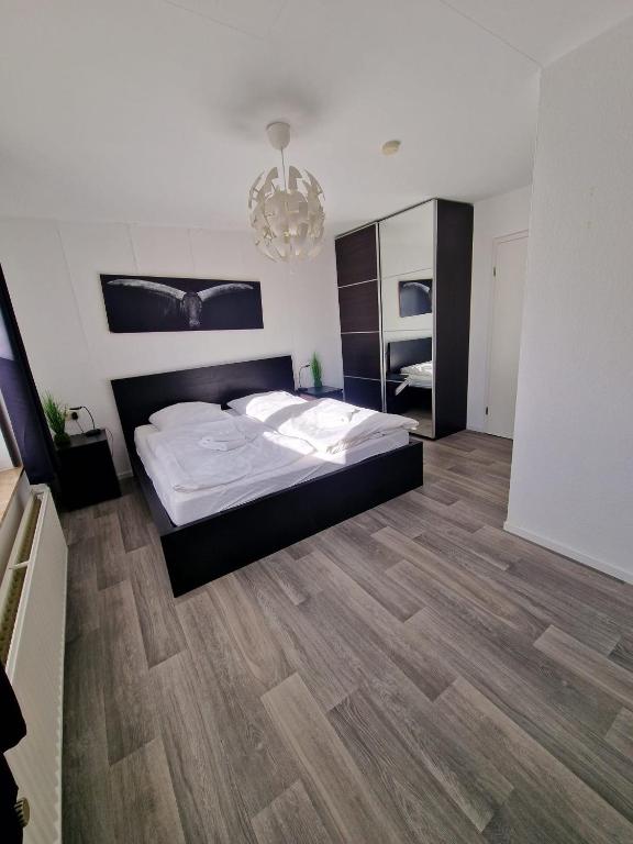 a bedroom with a large bed and a wooden floor at Ferienwohnung Büffel in Niedenstein