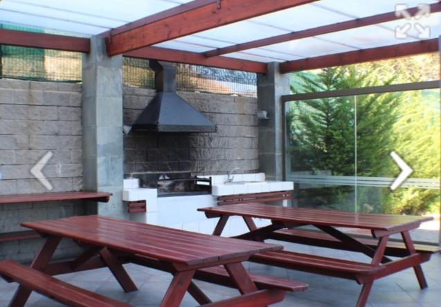 two picnic tables on a patio with a grill at Apartamento Eluchans Reñaca in Viña del Mar