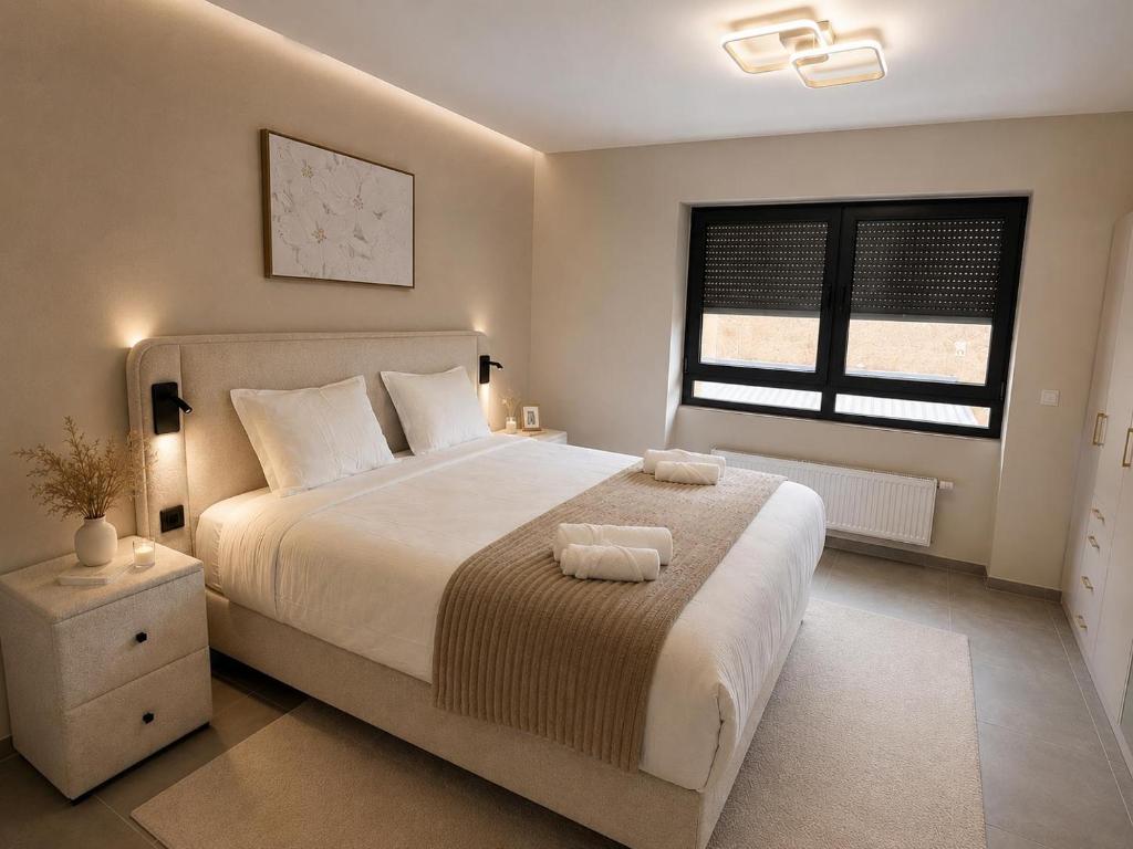 a bedroom with a large white bed and a window at The Eight in Luxembourg