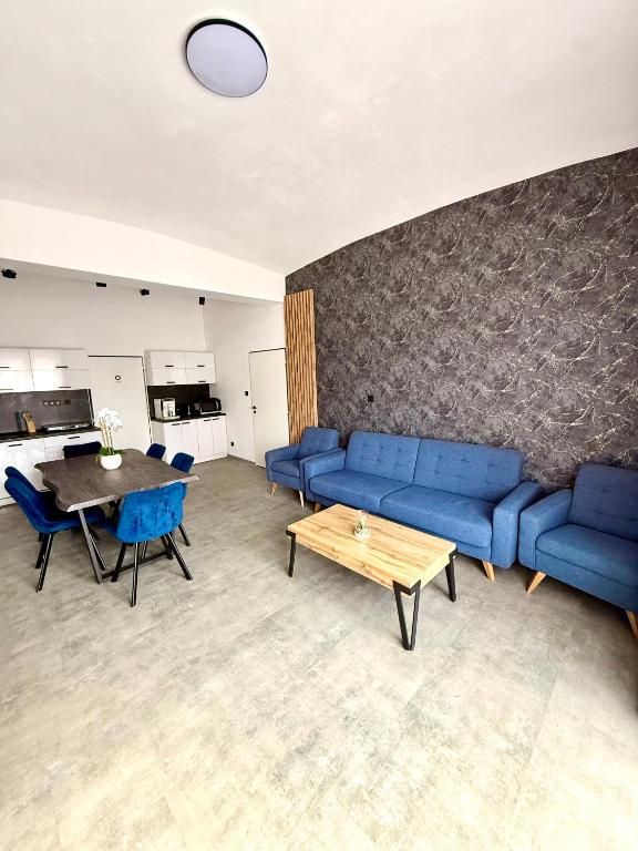 a living room with a blue couch and a table at Teplice Apartments 1 in Teplice