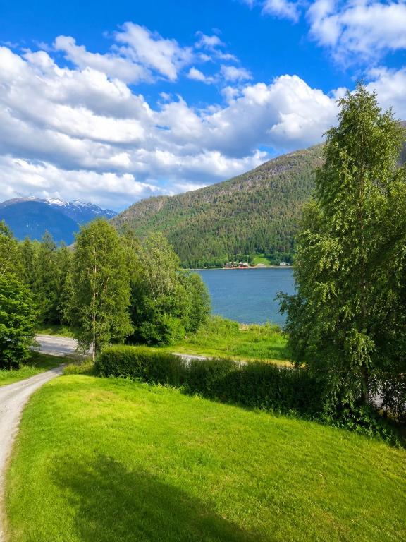 a road leading to a lake with mountains in the background at Fjordside Apartment in Åndalsnes