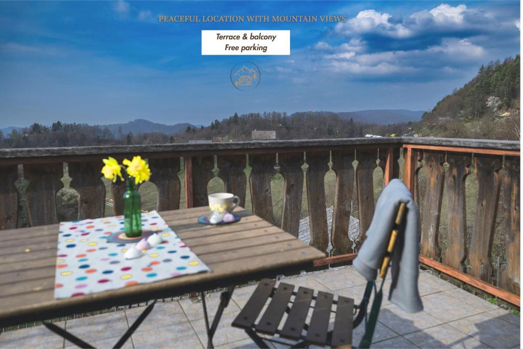 a table and chairs on a balcony with a table and flowers at Home in Heaven I Historical Log House in Šentrupert