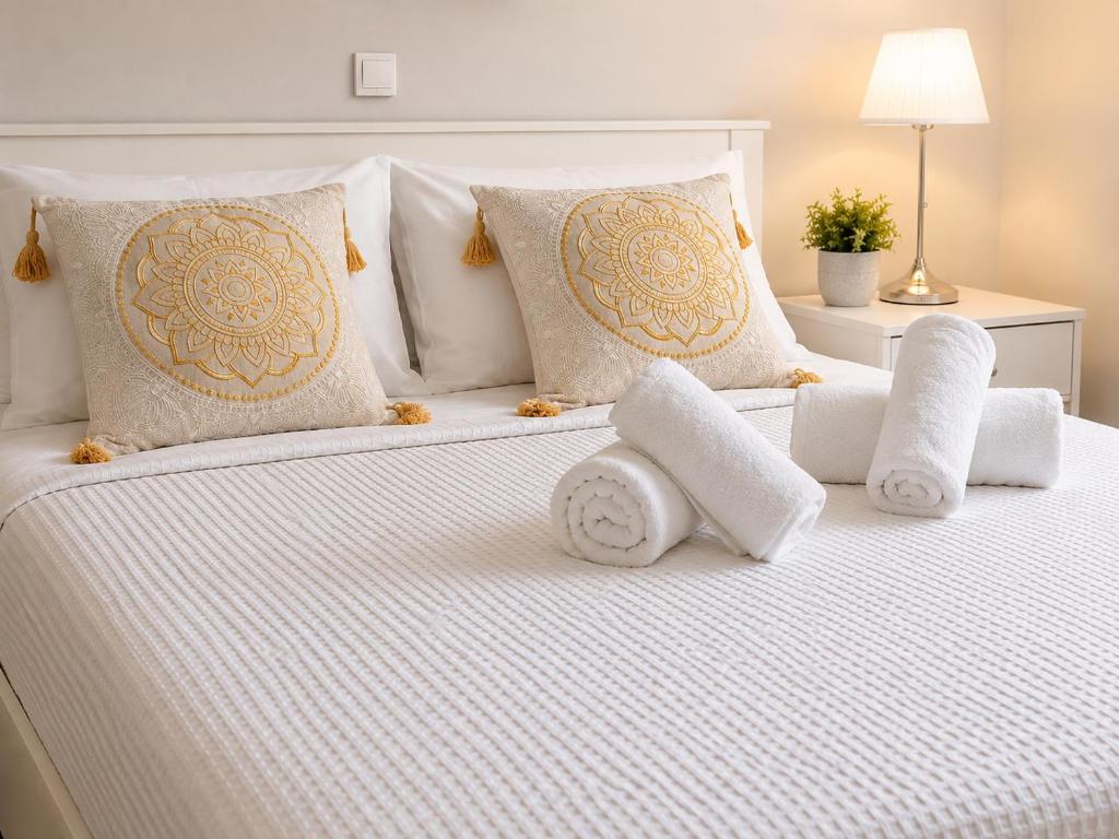 a white bed with pillows and towels on it at Elli's House - Apartment in Lixouri