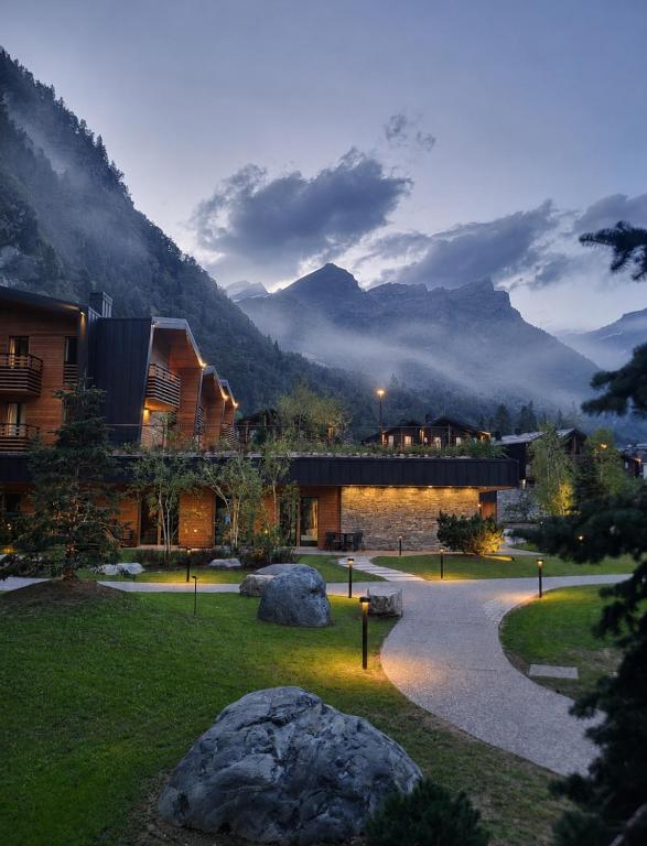a resort with rocks in front of a mountain at LVG Hotel Collection - Cascata d'Otro Mountain Lodge in Alagna Valsesia