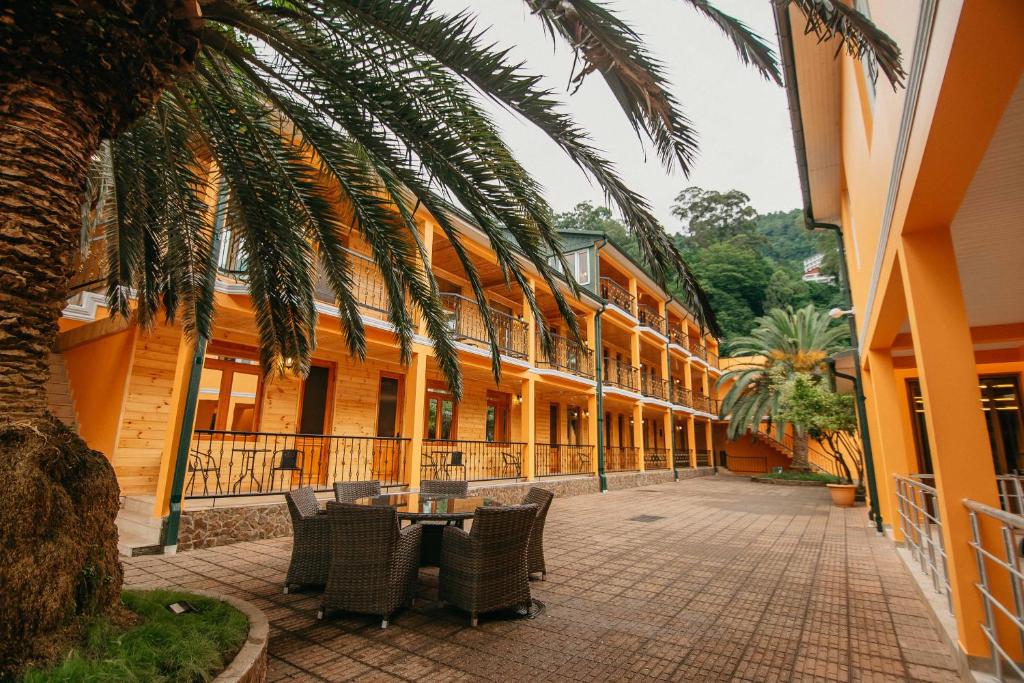 a courtyard of a building with a table and chairs at Villa Mirakula Kvariati in Kvariati