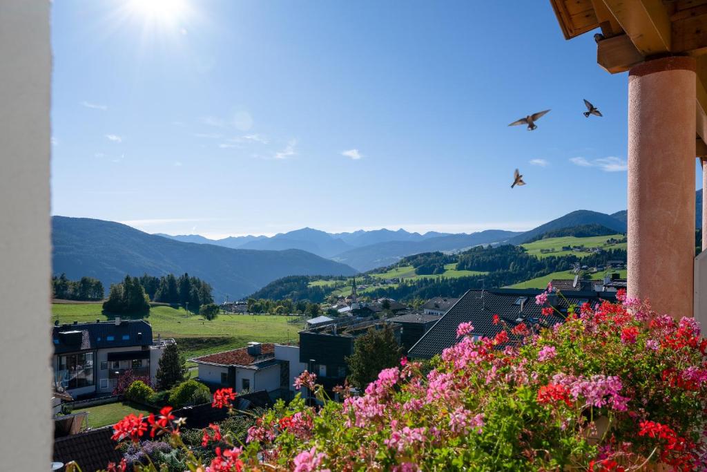 a town with flowers and mountains in the background at Residence Diana Apartment 201 in Terento