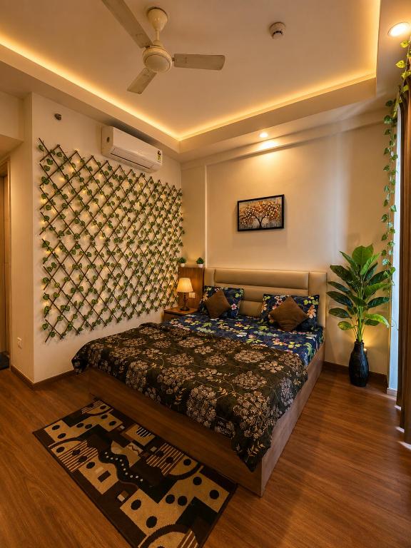a bedroom with a bed and a wall with a painting at The Sky cabin in Greater Noida