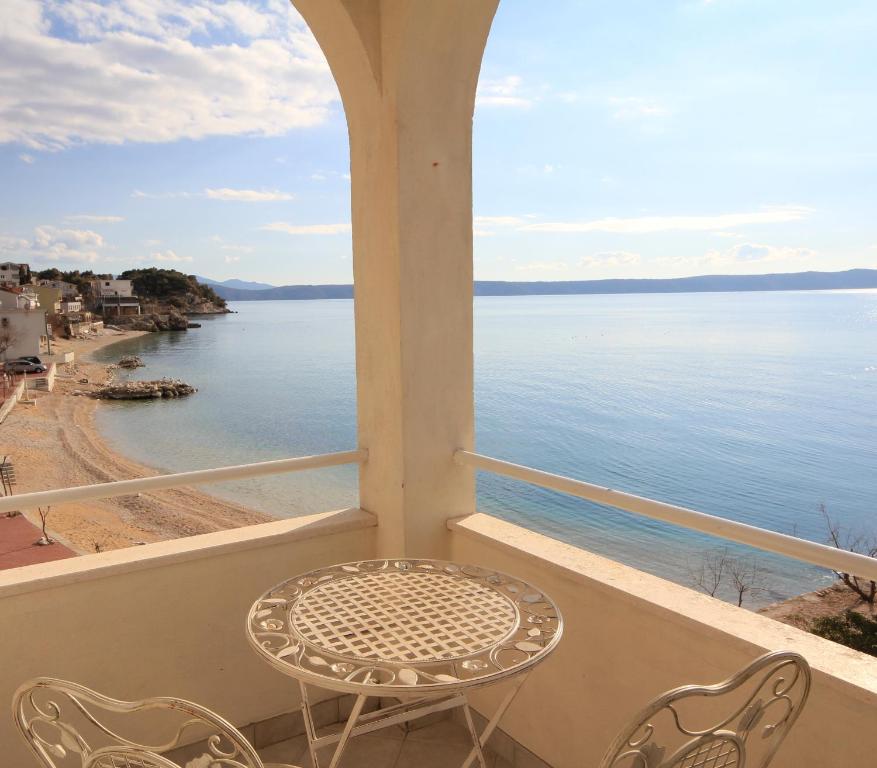 una mesa y sillas en un balcón con vistas al agua en Apartments Adrion, en Drasnice