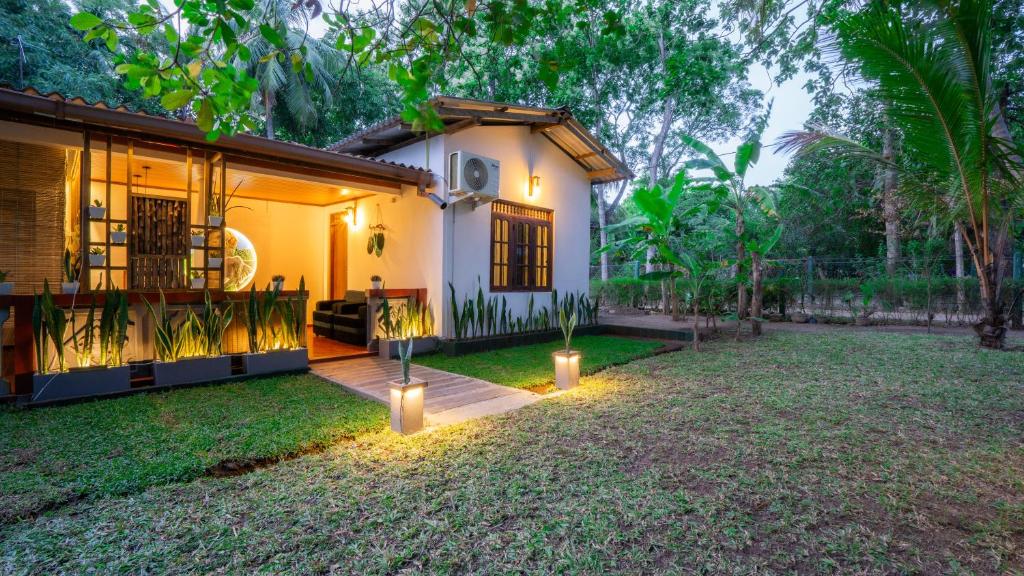a house with lights in front of a yard at Sansevieria Homestay in Sigiriya