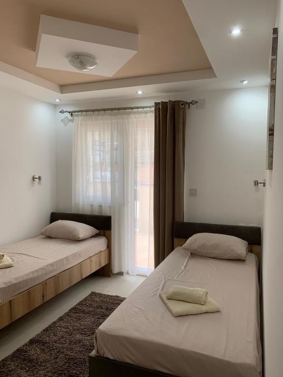 two beds in a room with a window at Eliksir 2 in Gornja Trepča