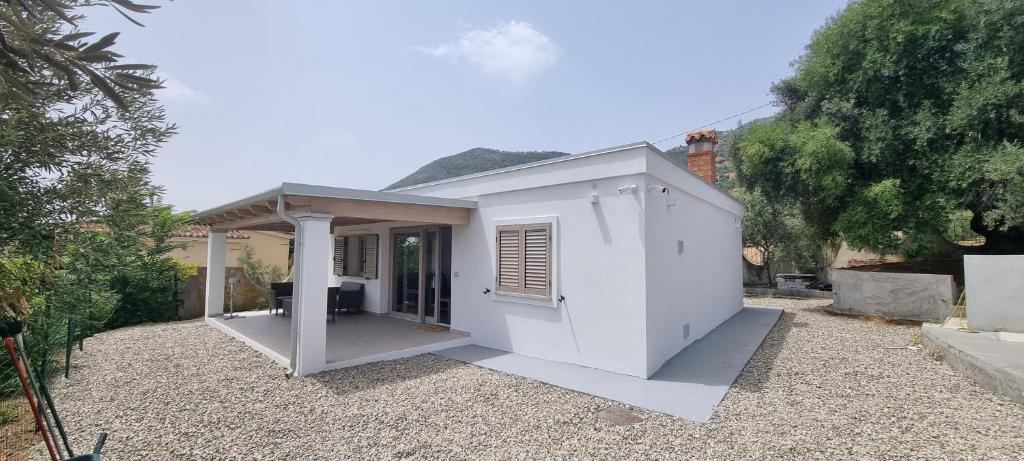 a small white house with a porch at Sa Omu de S'Olia in Tertenìa