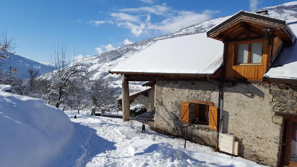 une maison recouverte de neige avec une montagne en arrière-plan dans l'établissement Le Chalet d'Augusta, à Bourg-Saint-Maurice