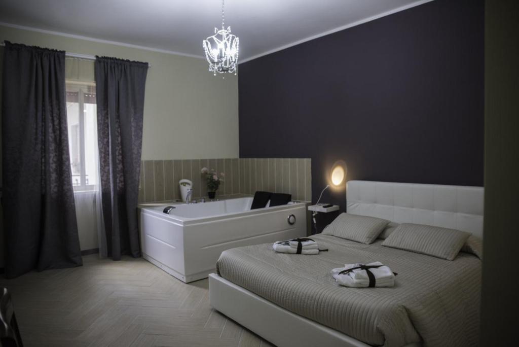 1 dormitorio con cama y bañera en Il Centro Short Lets, en Valguarnera Caropepe