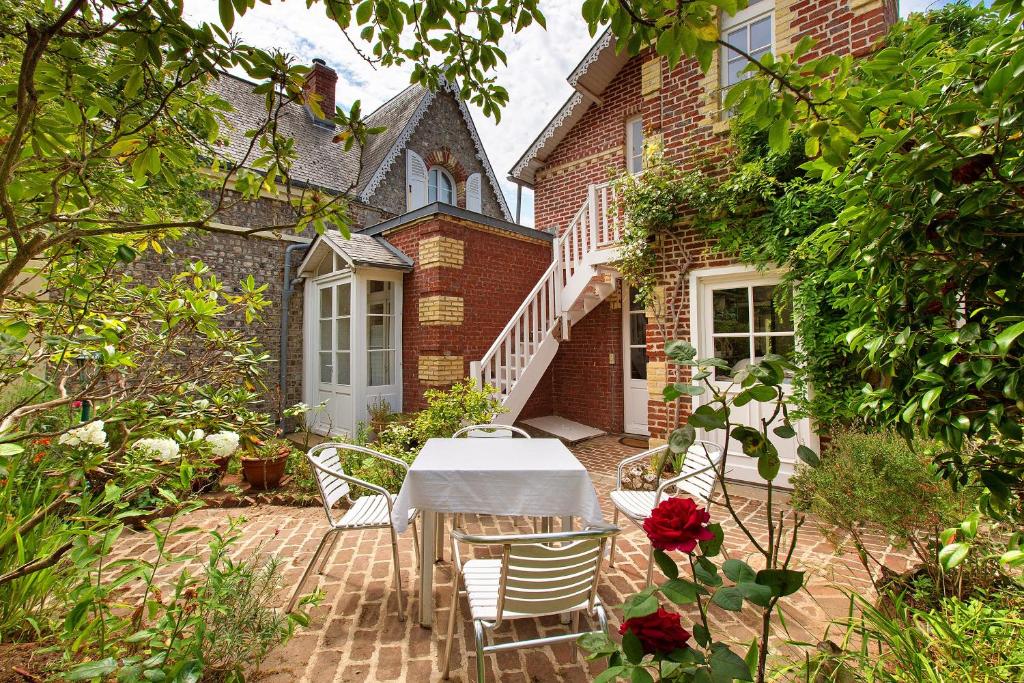 a table and chairs in front of a house at Les Soliers in Étretat