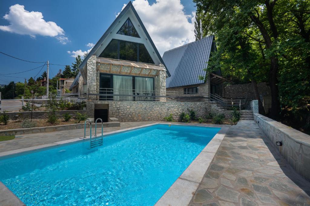 a house with a swimming pool in front of a house at LF Parnassos Chalet in Eptalofos
