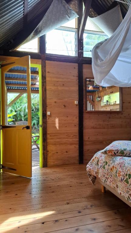 a bedroom with a bed and a window at La Case Tonton de Petite Île in Petite Île