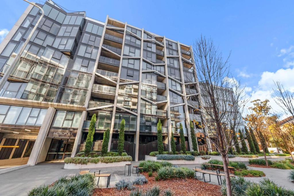 an apartment building with benches in front of it at 2BR-1BR-1Car- CBD Pool Central in Canberra