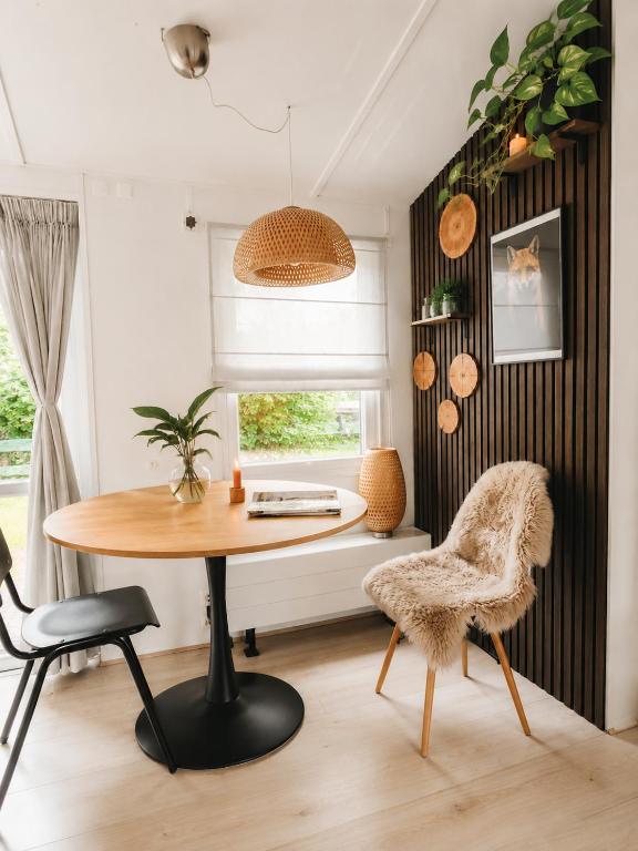a dining room with a table and a chair at The Red Shutter Cottage in Hattemerbroek