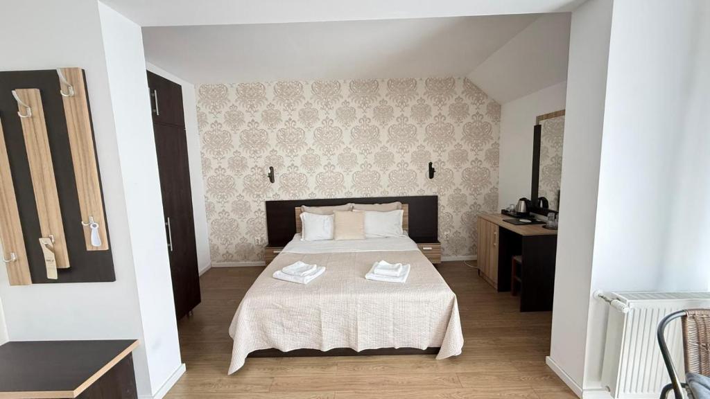 ein Schlafzimmer mit einem großen Bett mit weißer Bettwäsche in der Unterkunft Casa Mindru in Topliţa