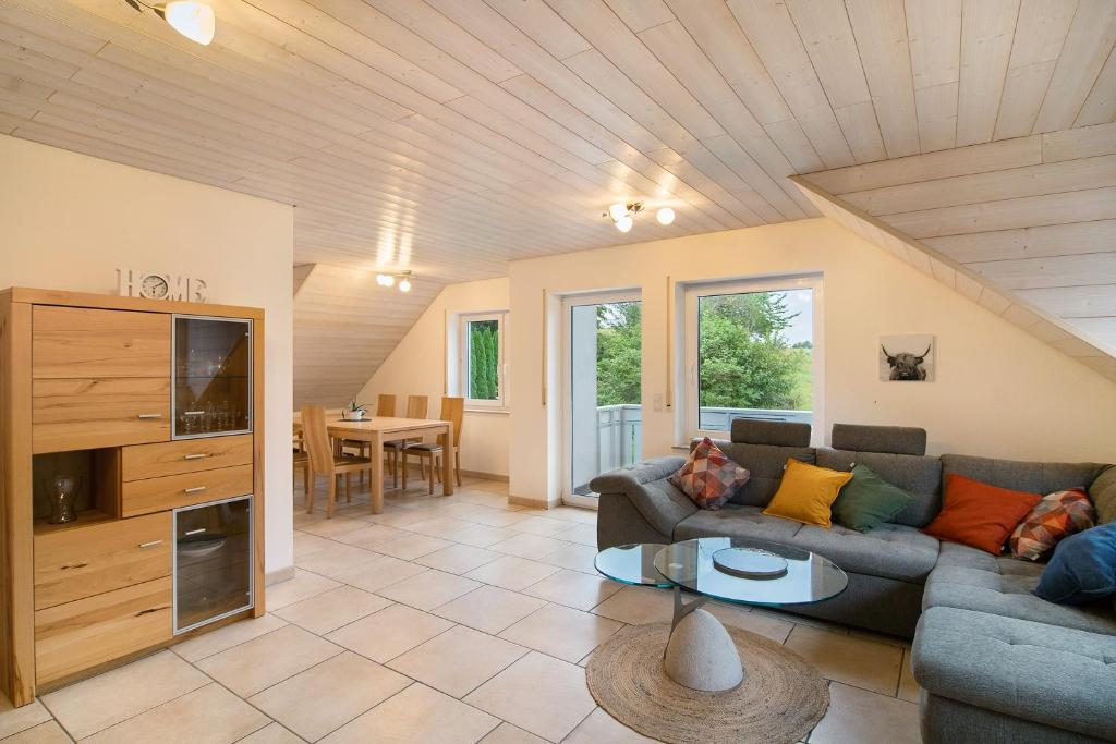 a living room with a couch and a table at Ferienwohnung "Am Hennenberg" in Erlenmoos