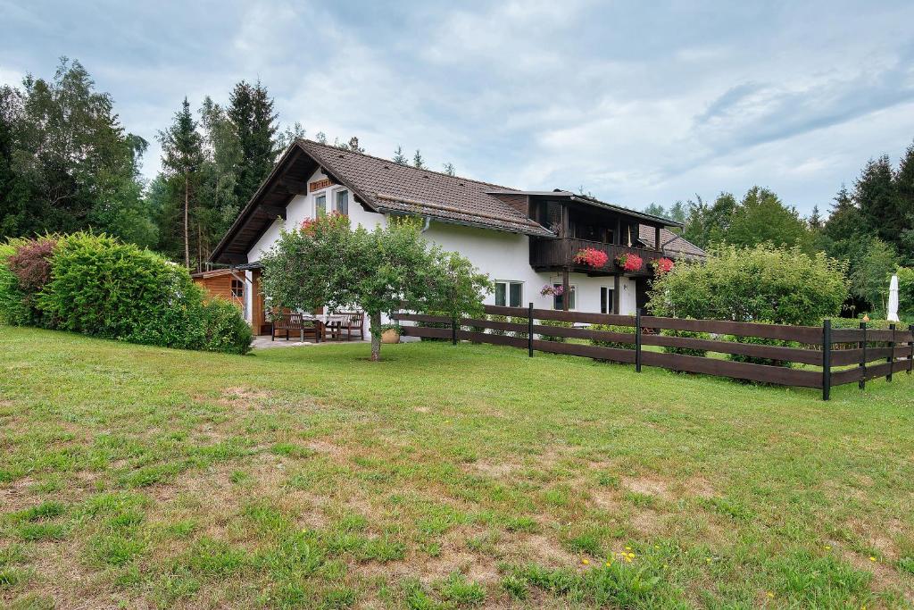 a house with a fence in front of a yard at Gemütliches 3-Sterne Ferienhaus in Zwiesel