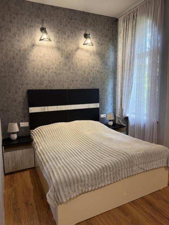 a bedroom with a large bed and two lamps at ElMar Guesthouse in Sevan