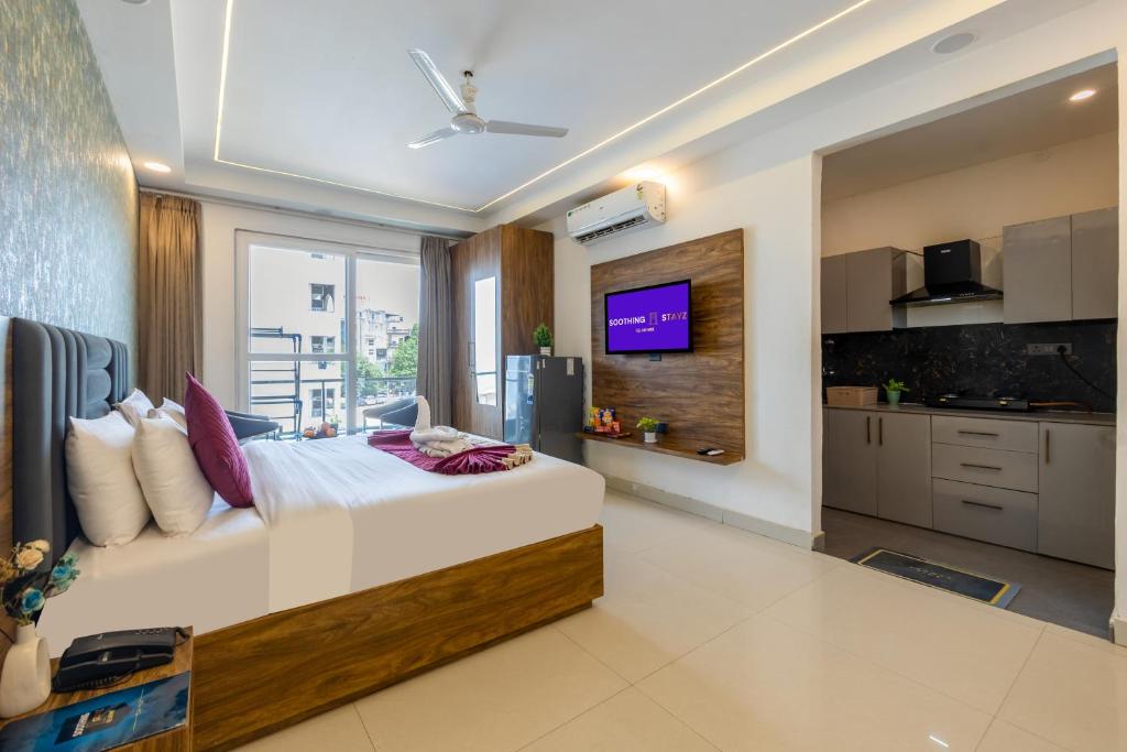 a bedroom with a large bed and a large window at Soothing Stayz - Near Medanta The Medicity in Gurgaon