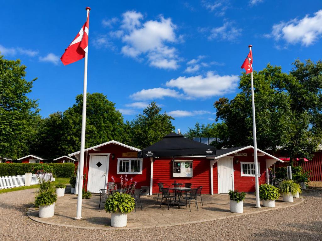 two canadian flags in front of a cabin at Rudbøl Naturcamping in Højer