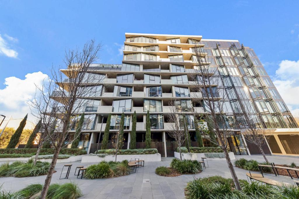 a tall building with benches in front of it at 2B-1BR-1Car-Courtyard-CBD-Shops in Canberra
