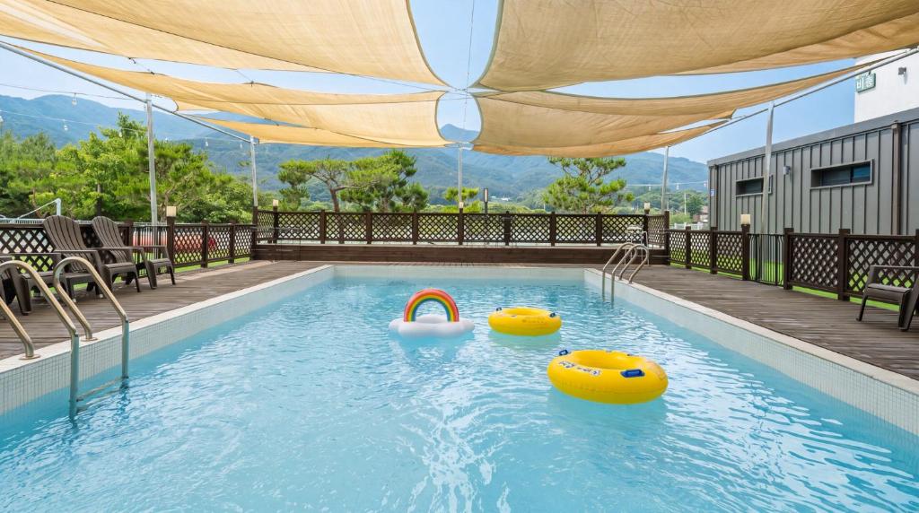 a swimming pool with two inflatables in the water at Gapyeong Dangdangi Pet Poolvilla Blue in Gapyeong