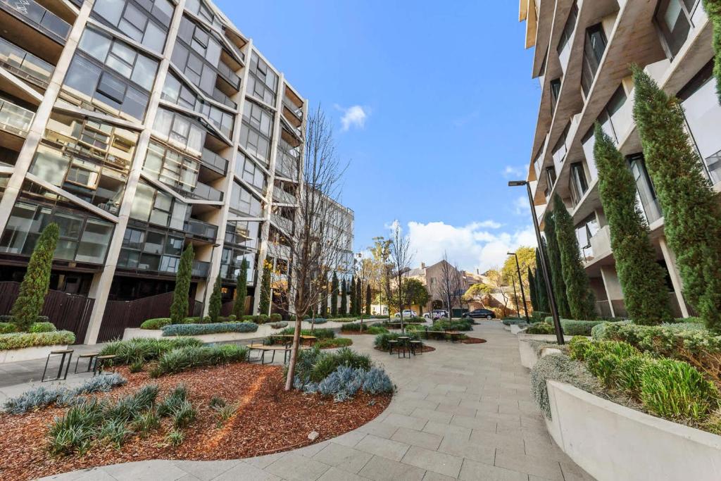 a sidewalk in front of a building with trees and plants at Central CBD - parking - sleeps 4 in Canberra