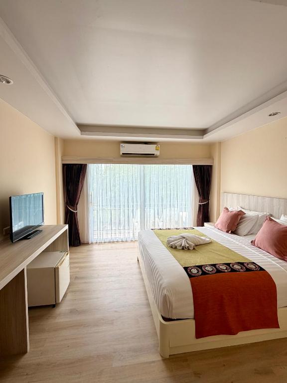 a bedroom with a large bed and a television at MM Hill Koh Samui Hotel - SHA Certified in Chaweng
