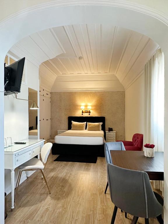 a hotel room with a bed and a desk at Hotel Joao Padeiro in Aveiro
