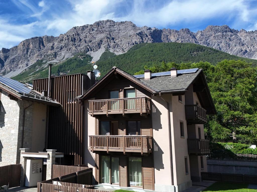 a building with a balcony and mountains in the background at Bormio BM0 - Tutta Bormio a Zero stress in Bormio