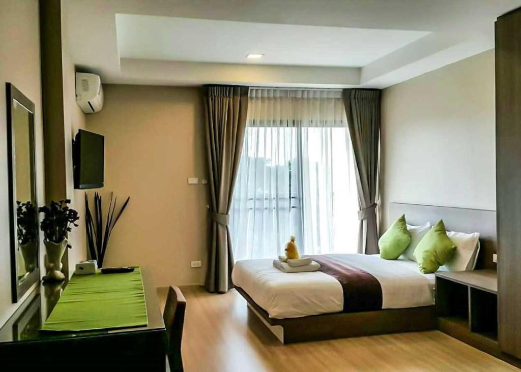 a bedroom with a large bed and a window at Perfect Smart Life Hotel in Ban Bang Toei (1)