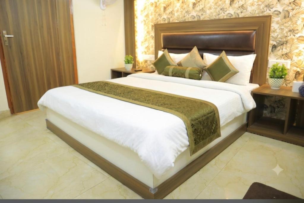 a bedroom with a large white bed with a wooden headboard at New sheth bnb golden temple in Amritsar