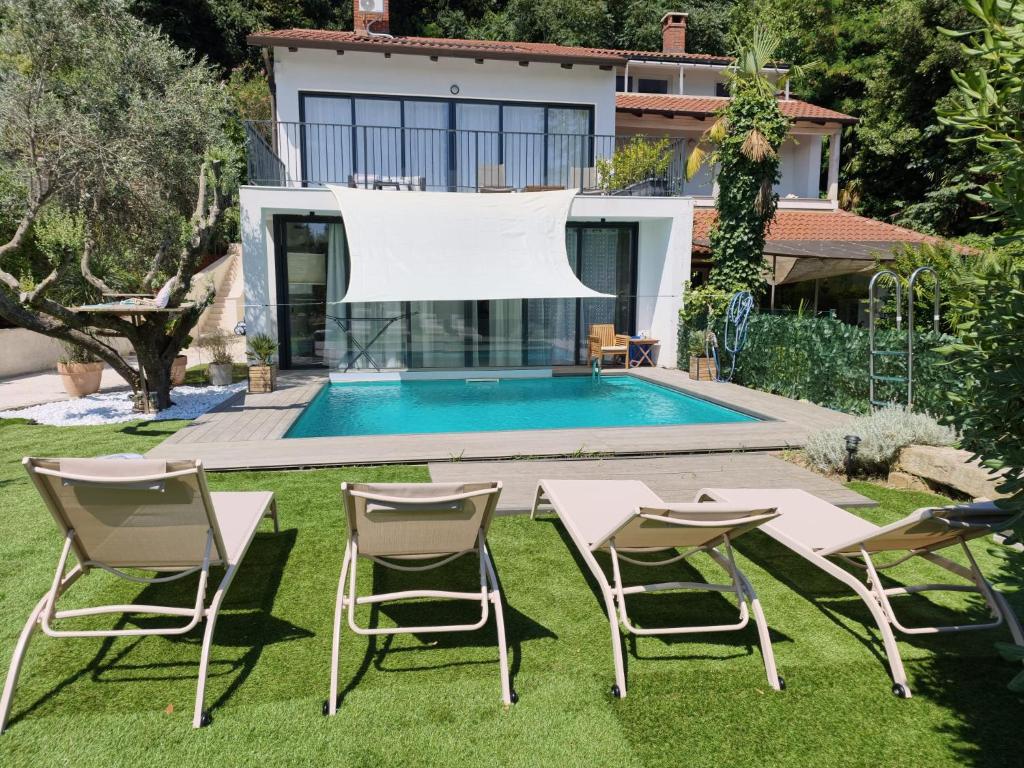a backyard with a table and chairs and a swimming pool at Rose in Portorož