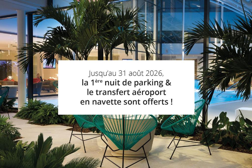 a sign in front of a building with palm trees at Oceania Paris Roissy CDG in Le Mesnil-Amelot
