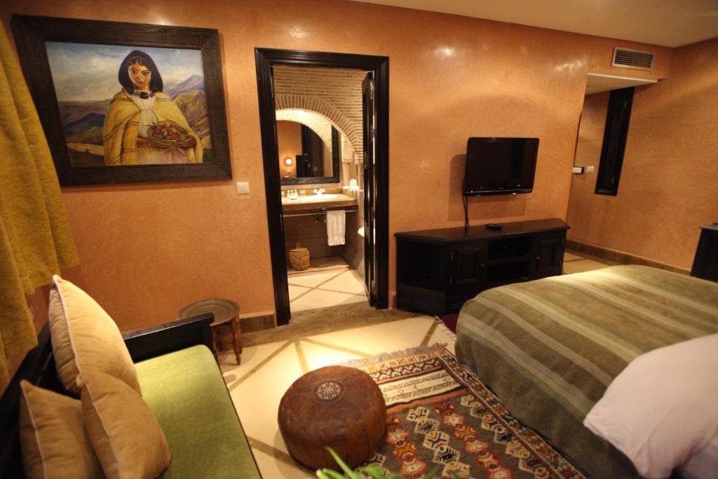 a hotel room with a bed and a mirror at Riad Dar Haven in Tamraght Ou Fella