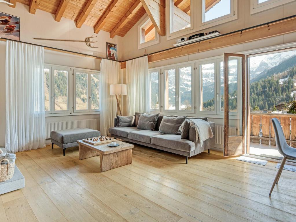 a living room with a couch and a table at Luxury Alpine Chalet with incredible Views in Lenk