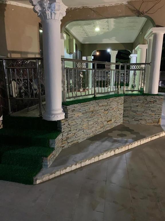 a porch of a house with a column and a fence at FREDJACKSAIR BnB in Koforidua