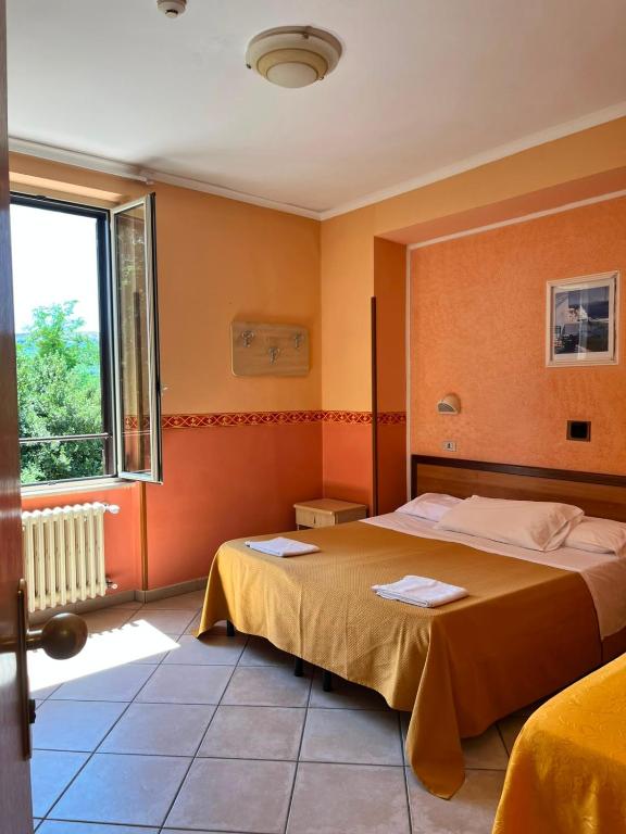 a bedroom with two beds and a window at Hotel Ludovici in Fiuggi