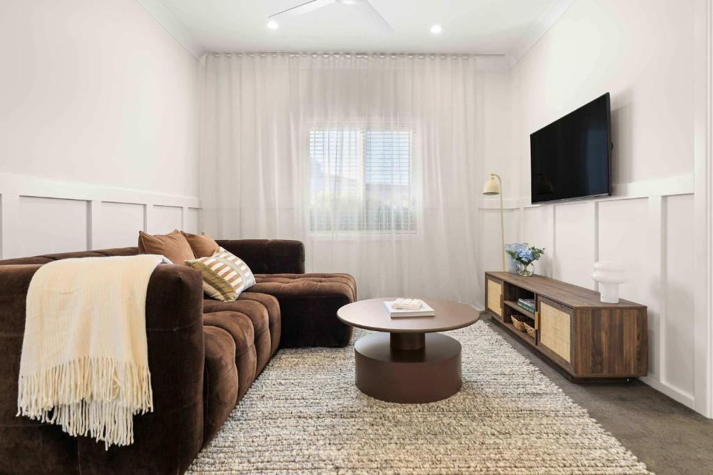 a living room with a couch and a tv at Sunday Valley in Cessnock