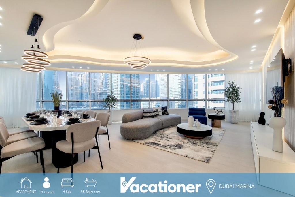 a living room with a couch and a table and chairs at Vacationer Holiday Homes I Stunning 4 Bed I 10 Min from Marina Mall in Dubai