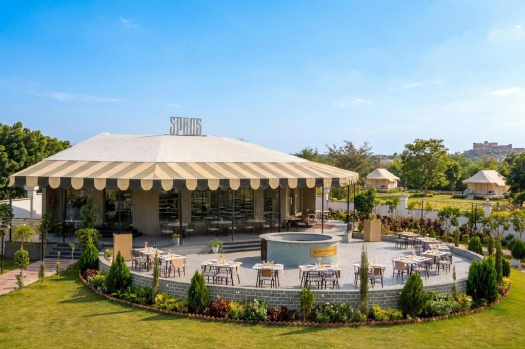 a pavilion with tables and chairs in a park at KMR Hotels & Resorts in Bikaner