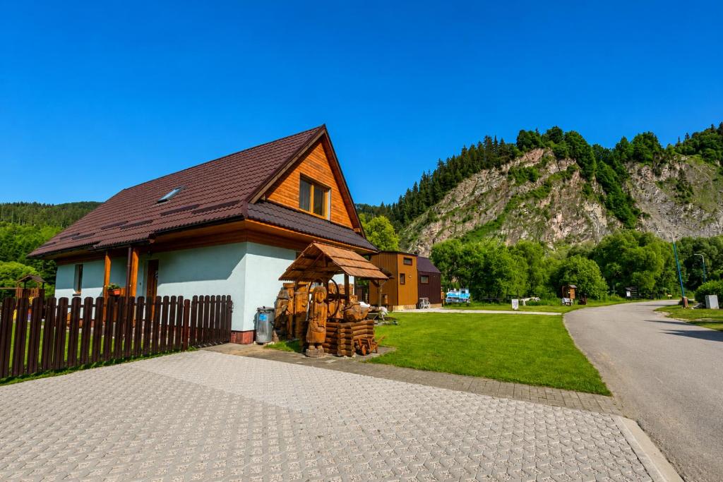 a house with a fence next to a mountain at Chata u pltníka Paľka in Podbiel