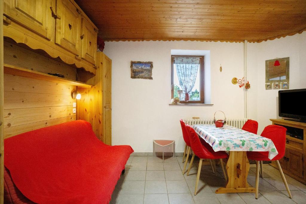 a dining room with a table and red chairs at Studio cabine - Les ecrins 2 in Valloire